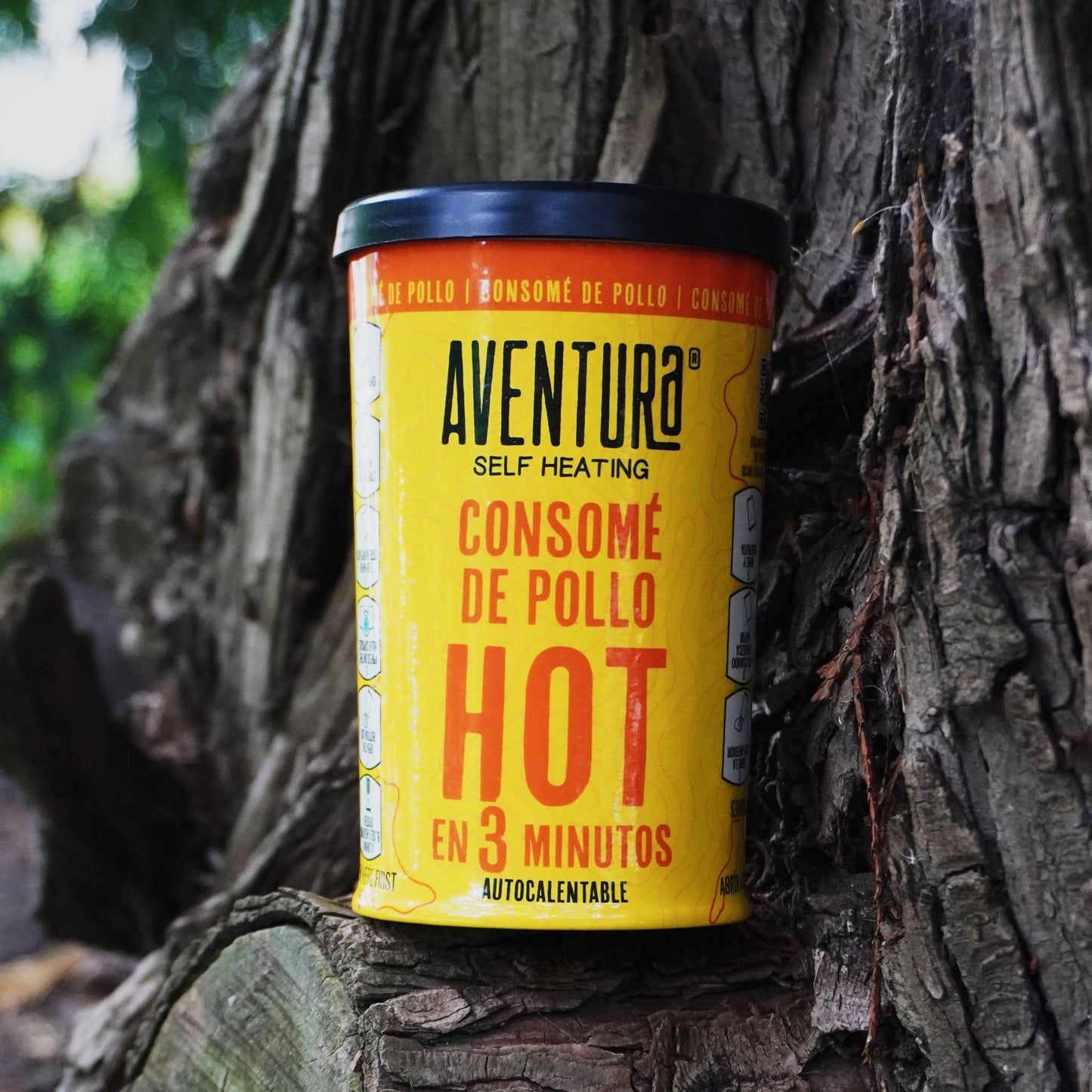 Aventura Self Heating Chicken Soup Hot in 3 Minutes resting on a tree outside.