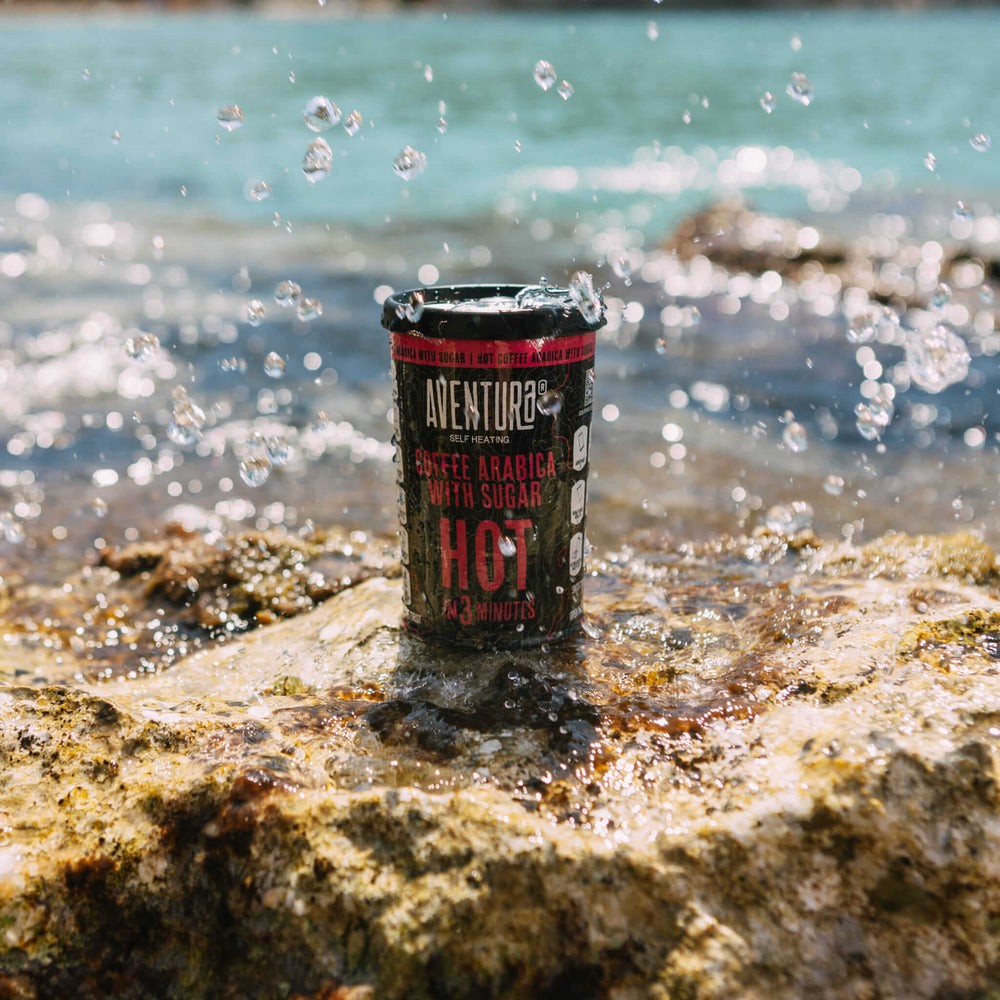 
                  
                    Aventura Self Heating Coffee Arabica with Sugar Hot in 3 minutes on a rock by water with some splashing of droplets on the can.
                  
                